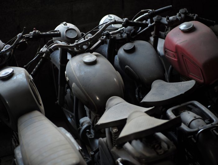 Old black and red motorcycle standing in a row in garage, horizontal picture