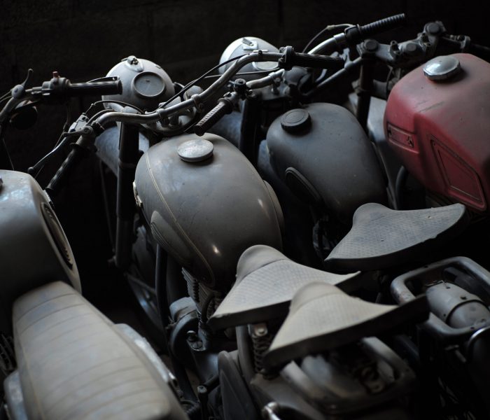 Old black and red motorcycle standing in a row in garage, horizontal picture